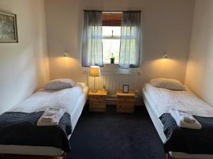 two twin beds in a room with a window at Engimyri Lodge in Akureyri