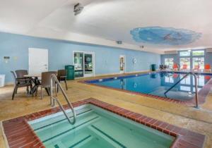 a large swimming pool in a room with a table and chairs at Comfort Suites At Rivergate Mall in Goodlettsville