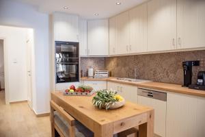 a kitchen with a table with a bowl of fruit on it at Anasasmos House in Naxos Chora