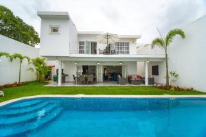 a villa with a swimming pool in front of a house at CASA HANNAH CON ALBERCA PRIVADA in Puerto Vallarta