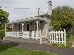 einen weißen Zaun vor einem kleinen Haus in der Unterkunft Cottage 79 in Orange