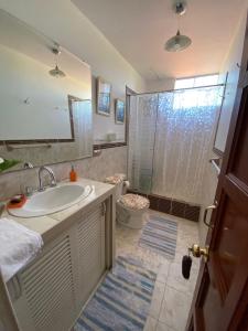 a bathroom with a sink and a shower and a toilet at Hospedaje Baños del Inca in Cajamarca