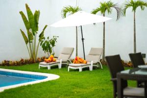 two chairs and an umbrella next to a pool at CASA HANNAH CON ALBERCA PRIVADA in Puerto Vallarta