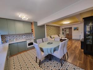Il comprend une cuisine et un salon avec une table et des chaises. dans l'établissement Bougainvillea Apartman, à Sfântu-Gheorghe