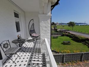 a porch with chairs and a table and a yard at Russell House in Paignton