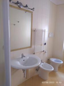 ein Badezimmer mit einem Waschbecken, einem WC und einem Spiegel in der Unterkunft Casa Ines in Maranola