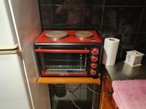 un horno tostador rojo sentado en la parte superior de un mostrador en Monoambiente a 300 metros del Obelisco, en Buenos Aires