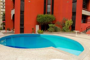 a blue swimming pool in front of a building at Belíssimo Flat em Pinheiros in Sao Paulo