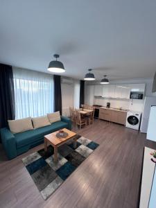 ein Wohnzimmer mit einem blauen Sofa und einem Tisch in der Unterkunft Fiesta Apartments in Mamaia Nord – Năvodari