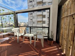 balcón con 2 sillas, mesa y ventana grande en ¡Hermoso departamento Bs As! en Buenos Aires