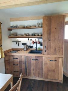 eine Küche mit Holzschränken und einem Waschbecken in der Unterkunft Ladybug Eco House 