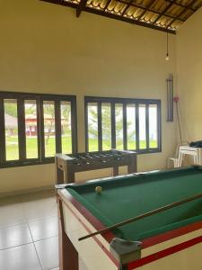 a pool table in the middle of a room with windows at Pousada Pratigi in Ituberá
