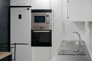 cocina con armarios blancos y microondas en Apartamento La Plana, en Castellón de la Plana