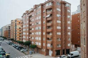 un edificio de ladrillo rojo en una calle con coches aparcados en Apartamento La Plana, en Castellón de la Plana