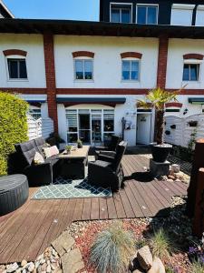 a patio in front of a house with chairs and tables at Das Haus am Kanal. in Lübeck