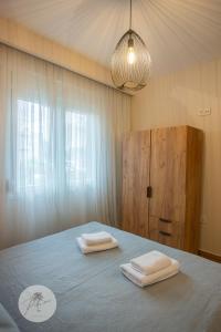 a bedroom with a bed with two towels on it at PALMERA STUDIOS in Ofrínion