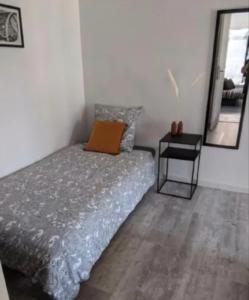 a bedroom with a bed with a mirror and a table at Maison 5 personnes in Mansigné