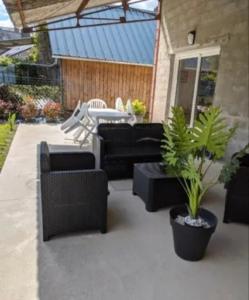 un patio con sofás, una mesa y una maceta en Maison 5 personnes en Mansigné