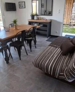 a living room with a table and chairs and a bed at Maison 5 personnes in Mansigné