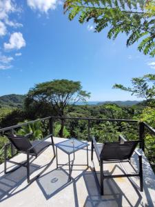 een patio met 2 stoelen en een tafel op een balkon bij Villa Martina Palmgarden in Sámara