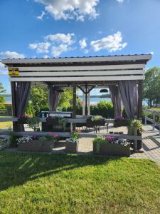 a gazebo with flowers in a park at Ekosfera Piława Apartamenty z podgrzewanym basenem in Borne Sulinowo