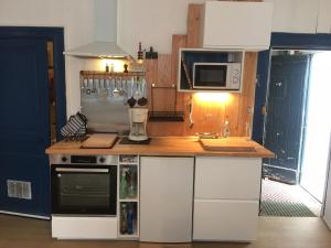 a kitchen with a stove and a microwave at Studio (T1) quartier Cathédrale in Tours