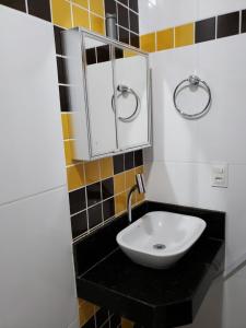 a bathroom with a sink and a mirror at Pousada Pratigi in Ituberá