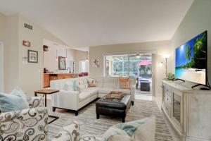 a living room with a white couch and a tv at Pet Friendly Pool Home in River Reach of Naples FL in Naples