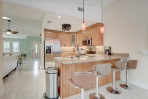 a kitchen with a counter and some stools in it at Pet Friendly Pool Home in River Reach of Naples FL in Naples
