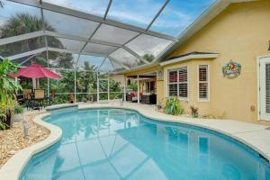 a swimming pool with a retractable roof and a house at Pet Friendly Pool Home in River Reach of Naples FL in Naples