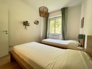 2 camas en una habitación con ventana en Kibilù - San Donato vicinanze IRCCS Policlinico, en San Donato Milanese