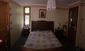 Schlafzimmer mit einem Bett und einem Kronleuchter in der Unterkunft maison vacances in Quézac