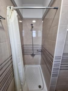 La salle de bains est pourvue d'une douche avec rideau de douche. dans l'établissement Sissy's Boutique Apartments, à Paralia Katerinis