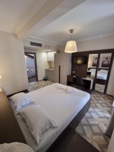 ein Schlafzimmer mit einem großen weißen Bett in einem Zimmer in der Unterkunft Sissy's Boutique Apartments in Paralia Katerinis