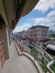 einen Balkon mit Blick auf eine Stadt mit Gebäuden in der Unterkunft Sissy's Boutique Apartments in Paralia Katerinis