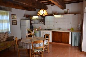 Il comprend une cuisine avec une table et un évier. dans l'établissement VILLA VITELLINO, à Castiglione del Lago