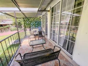 a screened in porch with two benches and a chair at Cozy Guest Studio Apartment in Downtown Boquete in Boquete