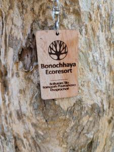 a tag hanging on a tree trunk at Bonochhaya EcoResort in Khagrāchari