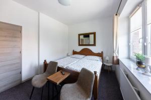 1 dormitorio con 1 cama, 2 sillas y mesa en Penzion a vinařství NATURVINI en Miroslav