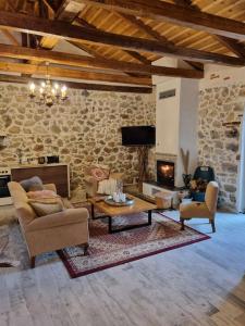 a living room with a couch and a fireplace at Stone House - Πέτρινο Σαλέ in Alíartos
