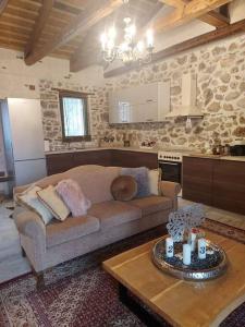 a living room with a couch and a table at Stone House - Πέτρινο Σαλέ in Alíartos
