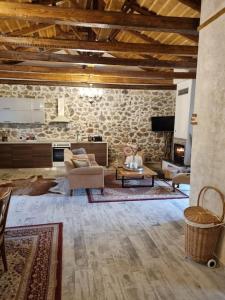 a large living room with a stone wall at Stone House - Πέτρινο Σαλέ in Alíartos