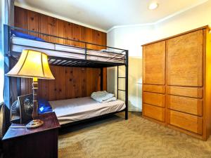 a bedroom with two bunk beds and a lamp at Bunk & Brew Historic Lucas House - Hostel in Bend