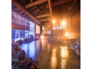 una piscina de agua en un edificio con rocas en Oyasukyo Onsen Ryokan Tarobee - Vacation STAY 56803v en Yuzawa
