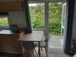 a kitchen with a table and chairs and a large window at Tinyhouse Wemding in Wemding