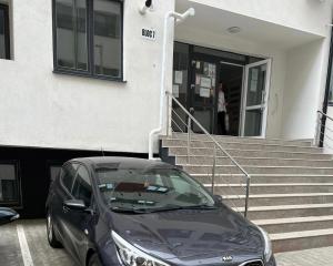 a black car parked in front of a building at Avangarde Apartment in Bucharest