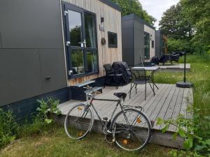 a bike parked on a deck next to a house at Tinyhouse Wemding in Wemding