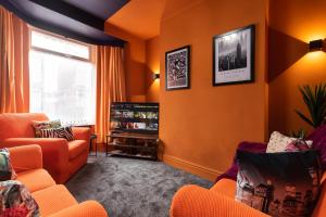 una sala de estar con paredes de color naranja y muebles de color naranja. en Ephphatha 4 Beds Central A63 3 Bedrms Free Wifi, en Hull