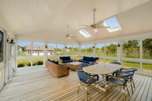 una veranda riparata con tavolo e sedie di Meadow Beauty a Westhampton Beach