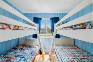 two bunk beds in a room with a window at Meadow Beauty in Westhampton Beach